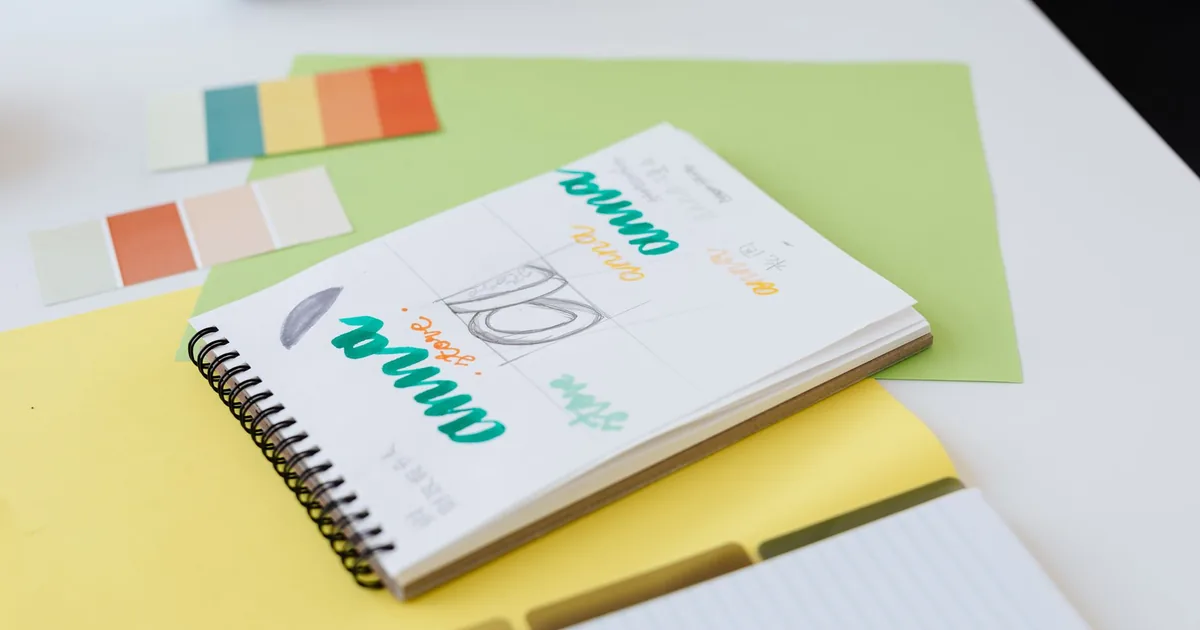 Mesa de trabajo con bocetos de logotipo y paleta de color